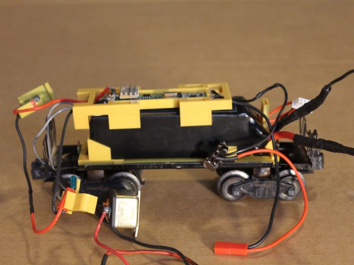 The receiver board, with wires soldered to it, and placed in its 3D-printed cradle, goes on top of the battery.